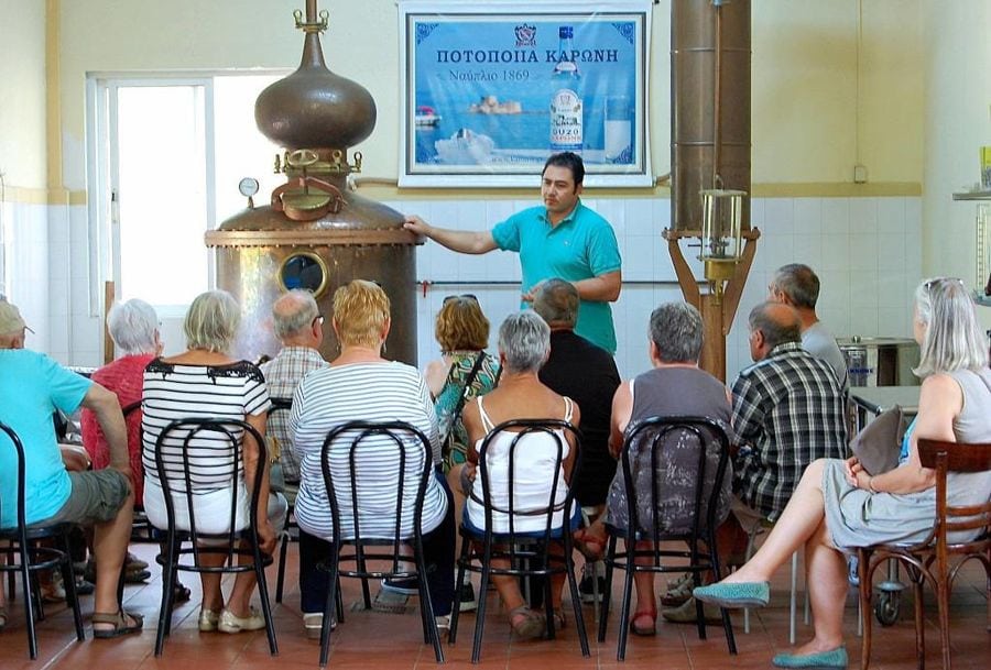 tourists listening to a guide at Karonis Distillery museum
